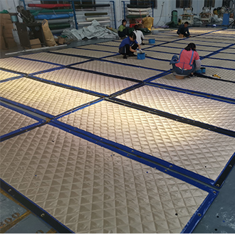 Workers produce printed waterproof sound insulation blankets
