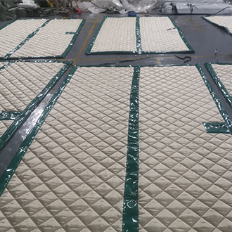 Workers produce printed waterproof sound insulation blankets