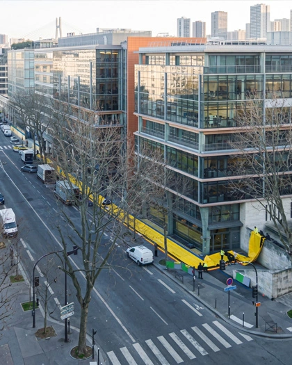 Portable flood barrier deployed around commercial building perimeters